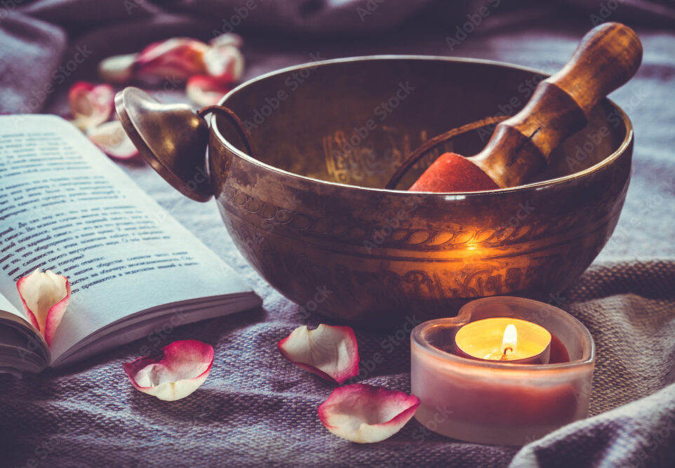 Beautiful sining bowl with a little candle and an open book